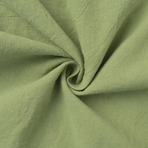 Close-up of sage green cotton fabric showing natural texture and soft drape detail
