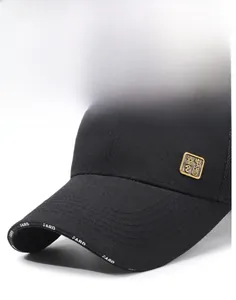 Close-up of black cotton baseball cap showing the gold metal badge and stiff brim details