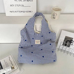 Détails du sac cabas en toile à carreaux bleus avec broderie florale et étiquette de marque