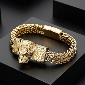 Detailed view of gold stainless steel wolf head charm on double-row curb chain bracelet