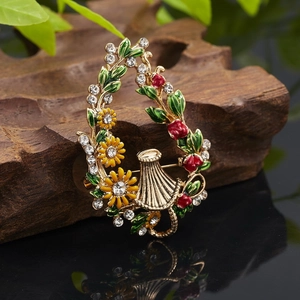 Detailed close-up of sunflower and berry brooch with colorful enamel on a gold base