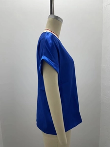 Detail of blue satin short sleeve t-shirt showing silky texture and smooth round neckline