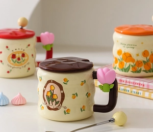 Detailed view of ceramic tulip mugs with matching lids and three-dimensional floral handles
