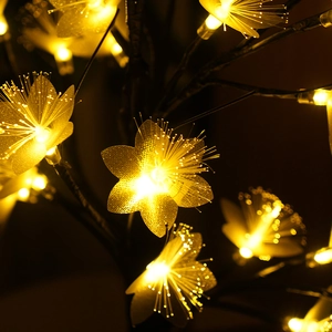 Close-up of golden fiber optic flower lights on a decorative birch tree lamp