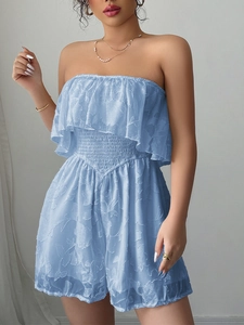 Elegante tuta blu senza spalline con motivo jacquard e dettagli di volant
