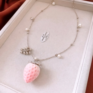 Detail of pink strawberry pendant with white pearl accents on silver chain necklace