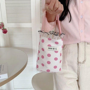 Close-up of pink polka dot canvas handbag with lace trim and Korean woven label