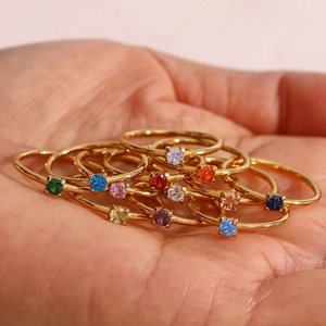 Group of slim 18K gold plated stainless steel birthstone rings with colorful round gems