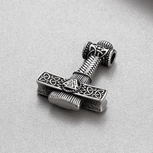 Macro detail of antique silver Viking Mjolnir pendant with Nordic runes and Celtic knots