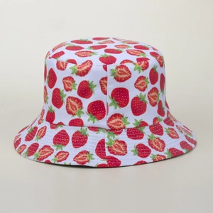 Gros plan des motifs de fraises et détails de couture sur un chapeau bob blanc en coton