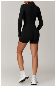 Back view of a slim-fit black seamless yoga set with high-waisted shorts and jacket