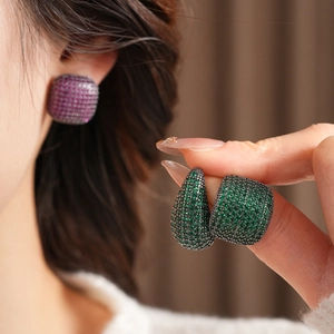 Gros plan d'une femme portant des boucles et bague vintage en or noir avec zircons