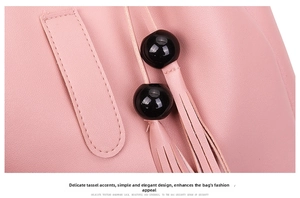 Detail of pink faux leather handbag showing tassel charm and black bead accents