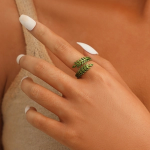 Detail of green enamel leaf ring in vintage bronze finish showing realistic plant texture