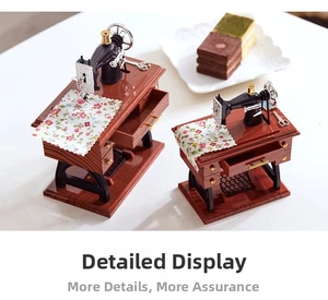 Detail of vintage sewing machine music boxes in two sizes with floral fabric on white table