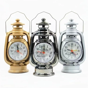 Detailed comparison of vintage kerosene lamp style alarm clocks in gold, silver, and gunmetal