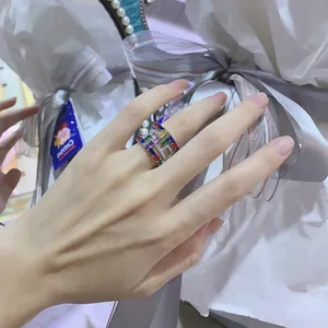 Macro shot of silver-plated wide band ring featuring multi-color rainbow cubic zirconia