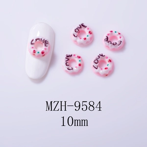 Pink resin donut nail charms with LOVE lettering and colorful sprinkles on white background