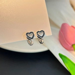 Gros plan sur boucles d'oreilles cœur en argent avec émail noir et poinçon S925