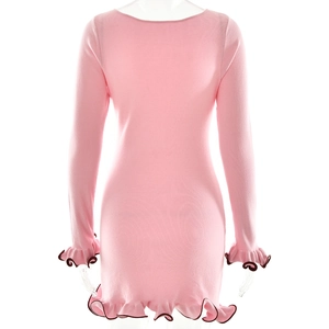 Detail view of the pink knit dress back featuring dark ruffled hem and sleeve cuffs