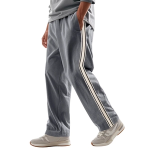 Detail showing grey corduroy texture and side stripes on loose-fit athletic pants
