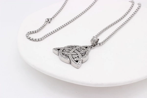 Macro shot of Viking triangle pendant with Speak With Love engraving and star symbols
