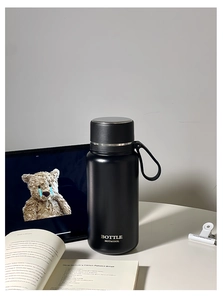 Close-up of matte black stainless steel insulated bottle with portable carry strap