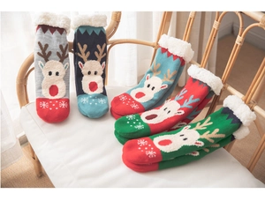 Fleece-lined Christmas socks with reindeer patterns on a cozy bamboo chair