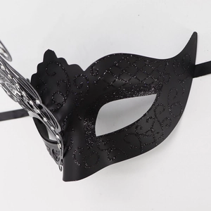 Close-up of black glitter butterfly masquerade mask with intricate cutout textures