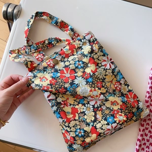 Detail view of floral cotton tote bag showing secure metal snap button closure