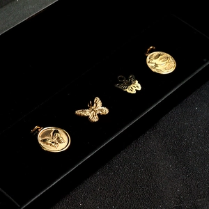 Vintage golden butterfly and bird pendants in a black velvet jewelry box for DIY necklaces