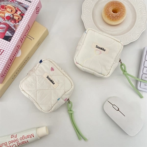 Quilted pouch detail featuring colorful heart embroidery and secure zipper closure
