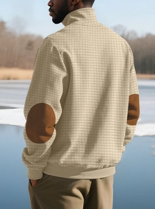 Detail view of beige textured knit sweater with brown suede elbow patches for men