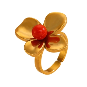 Detail of a gold four-petal flower ring with a red bead center and adjustable open band