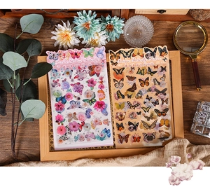 Macro detail of retro butterfly and floral stickers on a vintage wooden tray setup