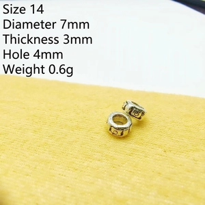 Macro detail of 7mm retro silver spacer beads with engraved patterns for DIY jewelry