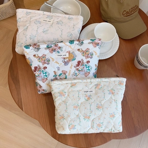 Quilted cotton hand bags with bear and floral prints on a cozy wooden table setup