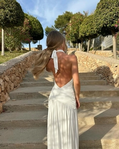 Detail of white backless halter dress with elegant pleats and long flowy silhouette