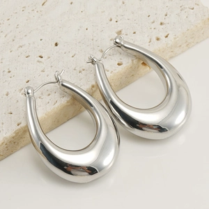 Macro view of silver water drop earrings featuring a polished mirror finish and stud closure