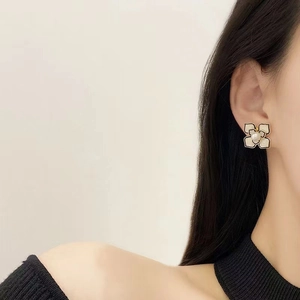 Elegant camellia pearl earrings featuring gold metal flower petals with black trim