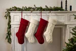 Close-up of red and white knitted Christmas stockings hanging on a vintage fireplace mantel