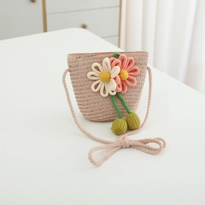Detail of hand-woven straw bag with 3D floral accents and delicate thin shoulder strap