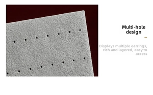 Detail of grey velvet earring display board with multi-hole texture for jewelry storage