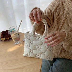 Quilted bunny pattern mini handbag in cream white shown in a cozy lifestyle setting