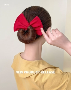 Rear view of a red fabric bow hair accessory styling a sleek bun bun hairstyle