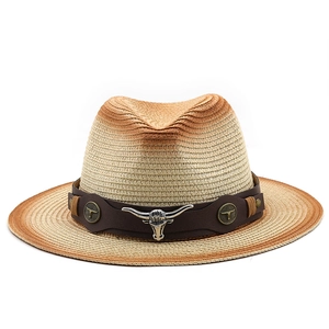 Détail d'un chapeau de paille de style western avec bandeau en cuir et emblème taureau
