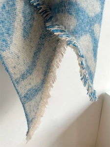 Gros plan d'une écharpe à motif nuage bleu et blanc avec détails de franges