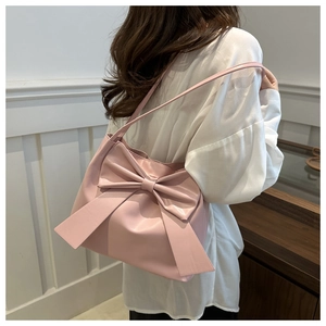 Close-up of pink bow decoration on a stylish PU leather shoulder bucket bag for women