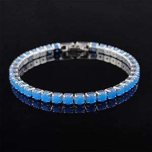 Detailed view of silver tennis bracelet featuring blue stones with a secure clasp