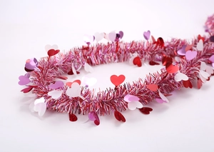 Detail of pink tinsel garland with colorful heart sequins for party atmosphere decor
